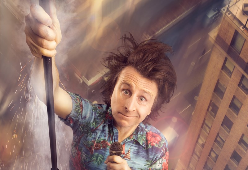 Milton Jones holding fan